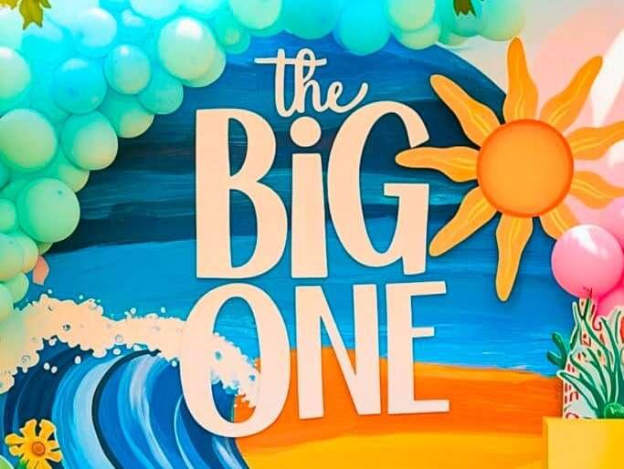Best First and Second Birthday Party Ideas for Boys and Girls 134 The Big ONE surf birthday party setup with three surfboard backdrop, pastel ocean tones, and themed table in horizontal layout.