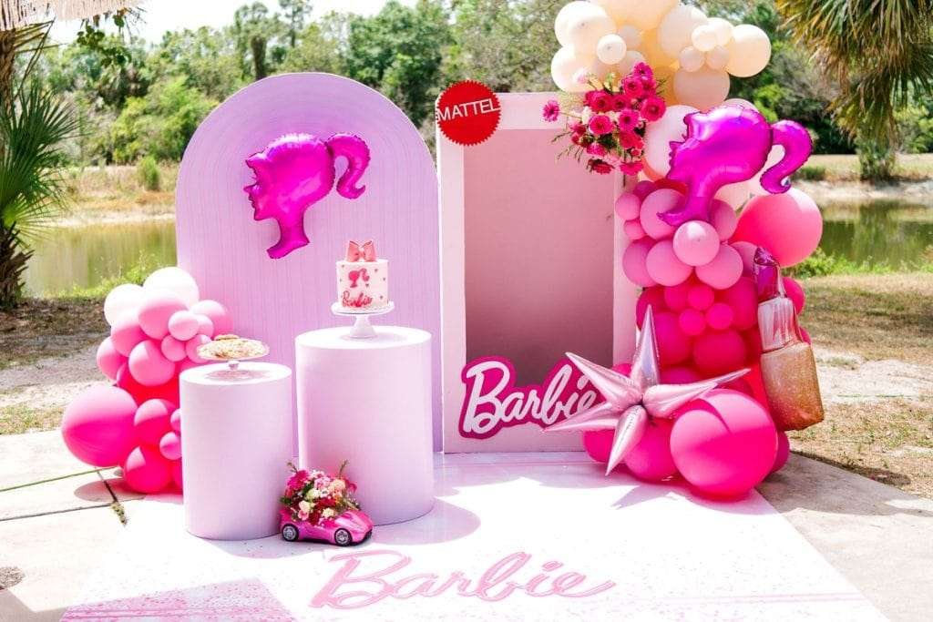 Best First and Second Birthday Party Ideas for Boys and Girls 45 Doll Box birthday party setup with life-size Barbie box, pink balloons, and themed cake for girls