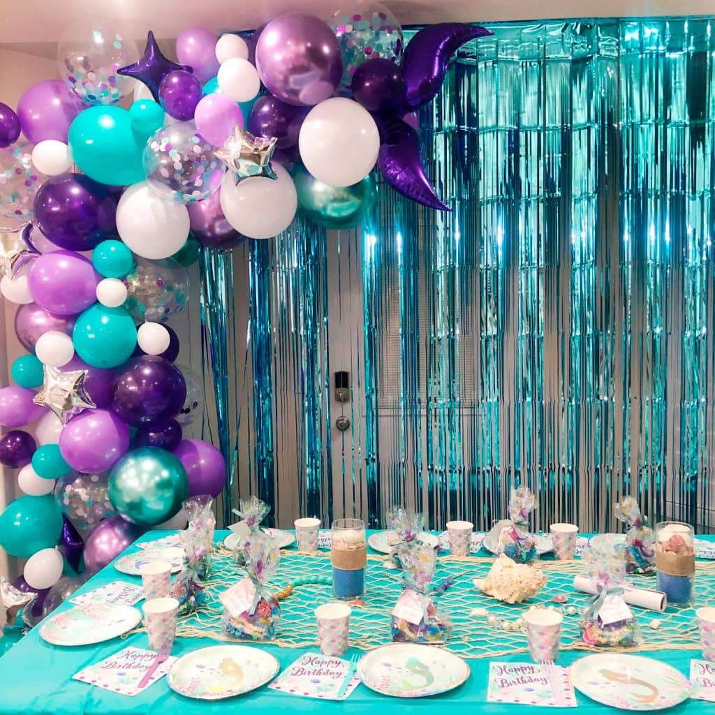 Best First and Second Birthday Party Ideas for Boys and Girls 70 Baby mermaid birthday party table setup with pastel balloons, seashell backdrop