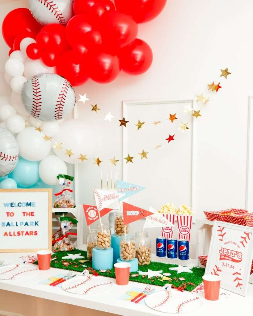 Best First and Second Birthday Party Ideas for Boys and Girls 26 Rookie of the Year baseball-themed birthday party table with red and white balloon garland, themed snacks, popcorn boxes, and pennant flags in a stylish horizontal setup.
