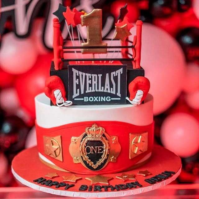 Best First and Second Birthday Party Ideas for Boys and Girls 7 Family celebrating a Round One boxing birthday party with red, black, and gold decorations, balloon arch, and themed desserts table.