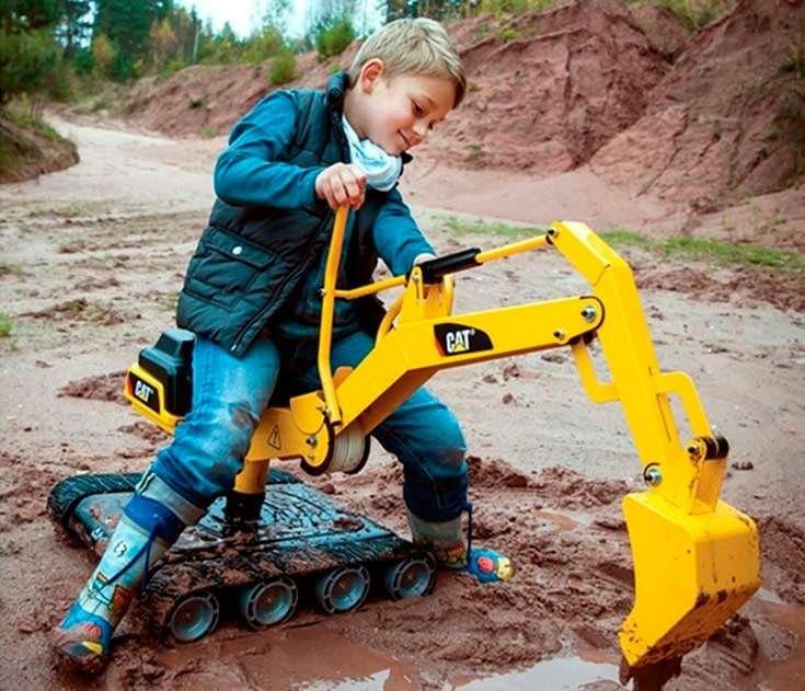 Kids using toy excavators and dump trucks in a digging station